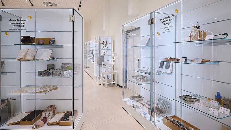 Innenansicht des Museums. Glasvitrinen mit Austellungsstücken, wie Werkzeuge und Bücher