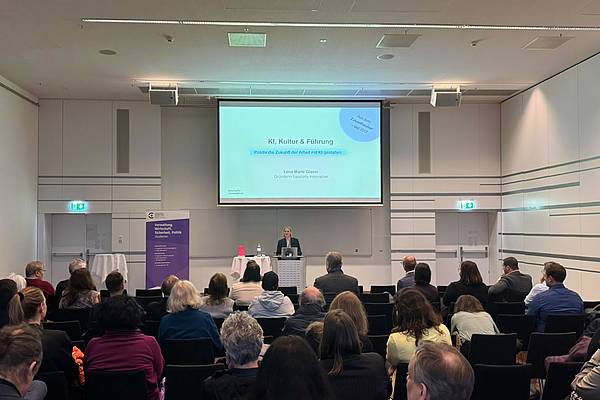 Lena Marie Glaser präsentiert am Rednerpult ihre Folien vor dem sitzenden Publikum.