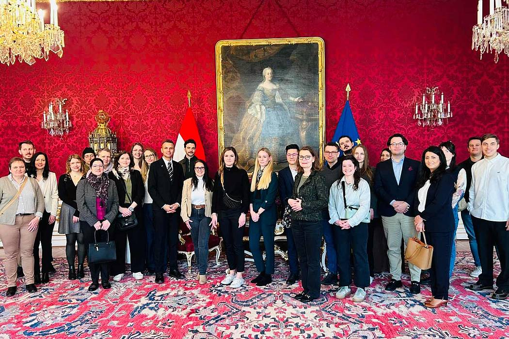 Die Gruppe steht vor dem Bild im Maria-Theresien-Zimmer in der Präsidentschaftskanzlei der Hofburg.