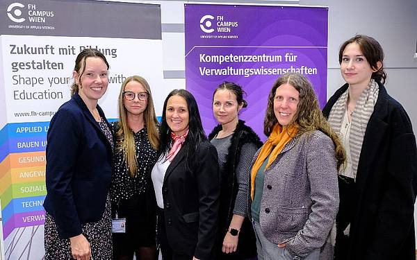 6 Frauen posieren für ein Foto, im Hintergrund sind Roll-ups zu sehen