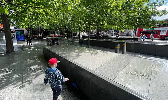 Ein Kind spielt in einer Stadt mit viel Asphalt 