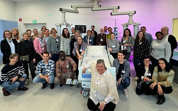 Einge Gruppe von Personen rund um ein Krankenbett mit monitoren und pflegerisch technischen GerätenGeräten 