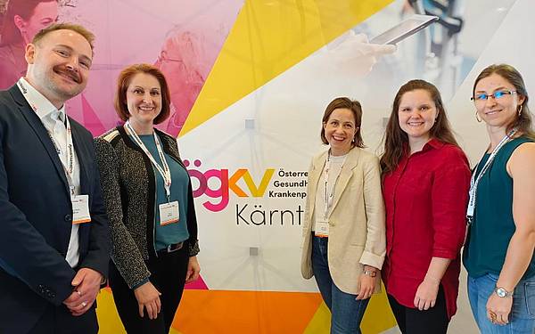 Fünf Personen vor einer Wand, auf der ÖGKV Kongress zu lesen ist