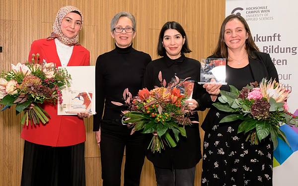 Vier Frauen stehen auf einer Bühne und halten ihre Blumensträuße