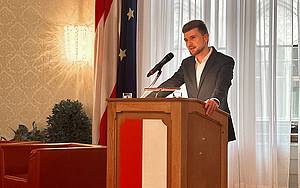 Mann steht an einem Rednerpult