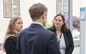 Personen stehen nebeneinander und sprechen miteinander