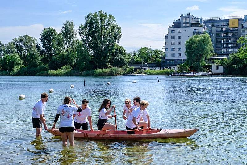 Studierende lassen ein Kanu zu Wasser