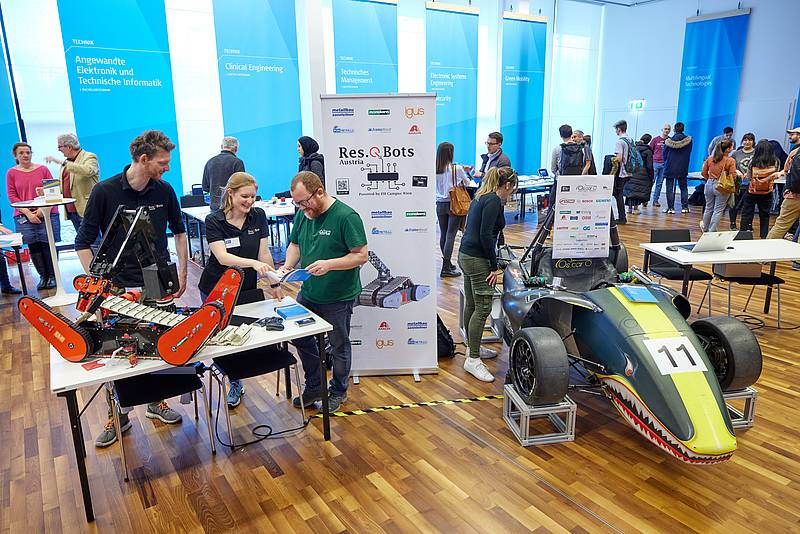 Im Zentrum des großen Messesaals befindet sich ein Info-Stand des Oscar Racing Teams und der Rescue Bots der Hochschule Campus Wien inkl. eines Rennautos und Roboters. 
