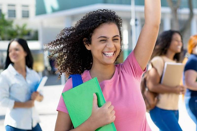 Gut gelaunte Studierende vor Hochschulgebäude