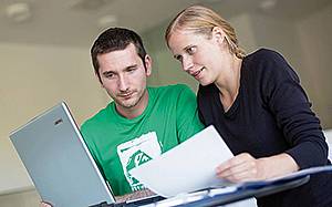 Zwei Personen arbeiten gemeinsam am Laptop
