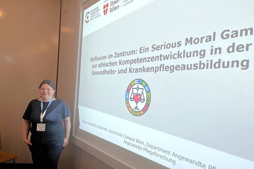 Eine Frau vor einer projezierten Präsentation mit dem Titel Serious Moral Game