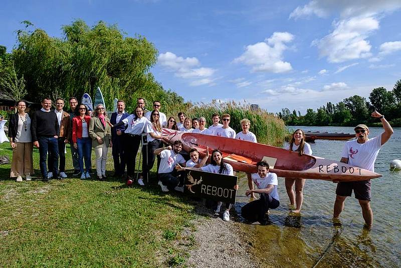 Eine Gruppe trägt ein Kanu in einen Fluss