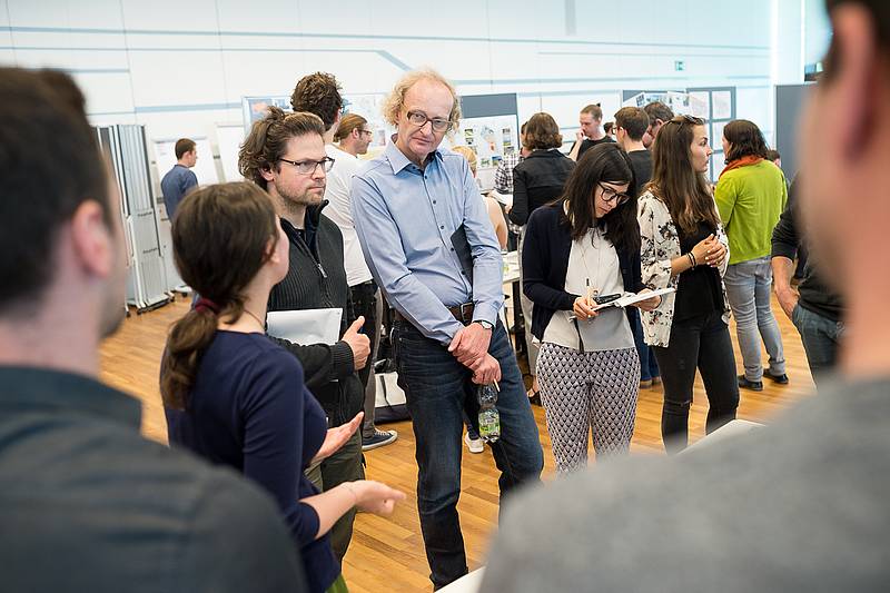 Lehrende und Jurymitglieder stehen in Saal