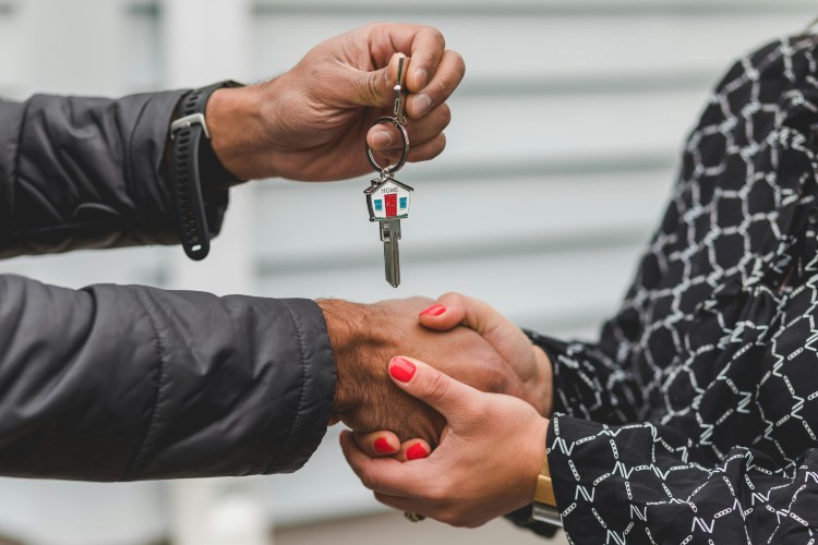 © pexels.com/RDNE Stock project Eine Nahaufnahme der Hände zweier Personen. Eine Person überreicht mit einer Hand einen Schlüsselbund; die zweite Person greift dankend die freie Hand der ersten Person.