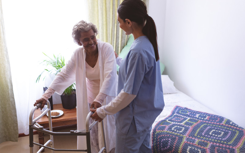 A nurse supports an older lady