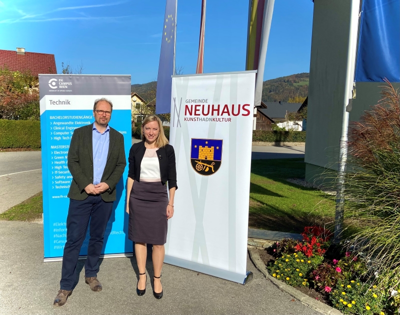 Amtsleiterin Regina Wiedl und Professor F H Heimo Hirner vor Rollups der F H Campus Wien und der Gemeinde Neuhaus