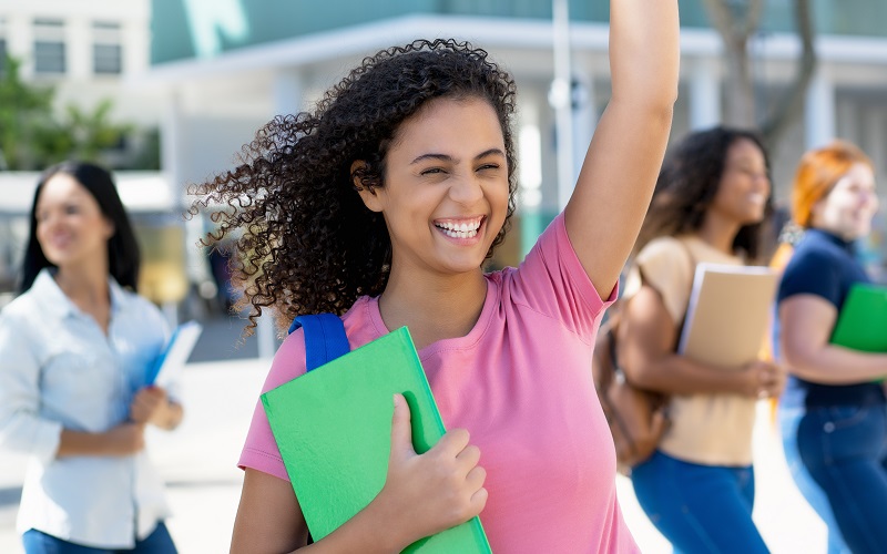 Gut gelaunte Studierende vor Hochschulgebäude