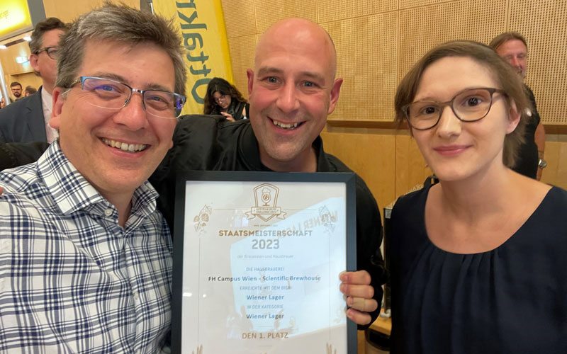 Drei Personen mit Urkunde