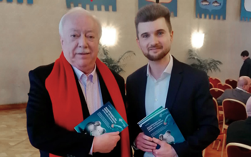 © David Majcen Zwei Männer stehen nebeneinander und halten jeweils ein Buch in der Hand