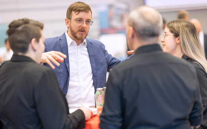 © HCW/Djumic Personen stehen nebeneinander und reden miteinander