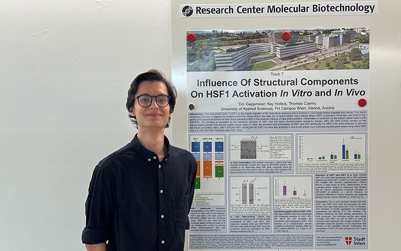 Mann steht vor einem Poster