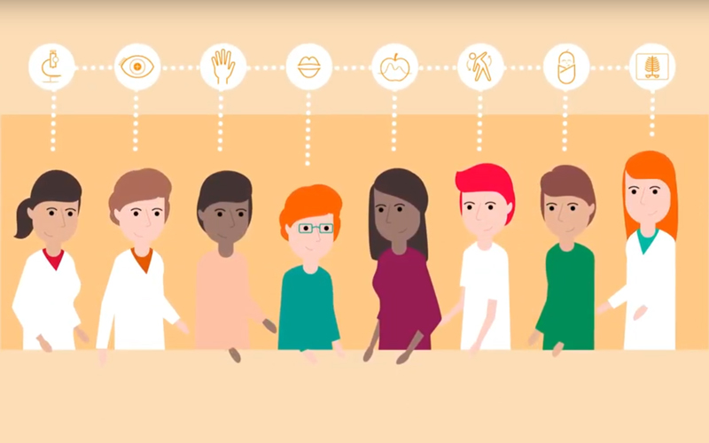 Personen mit unterschiedlichen Gesundheitsberufen stehen zusammen an einem Tisch