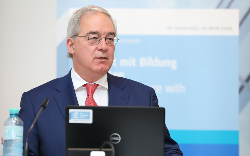 Vizerektor Arthur Mettinger steht an einem Pult vor einem Laptop und hält eine Rede