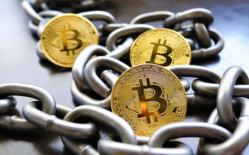 einige Bitcoins und eine Metallkette