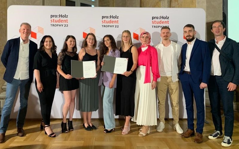 Eine Gruppe an Studierenden und Lehrenden mit Urkunden in der Hand.