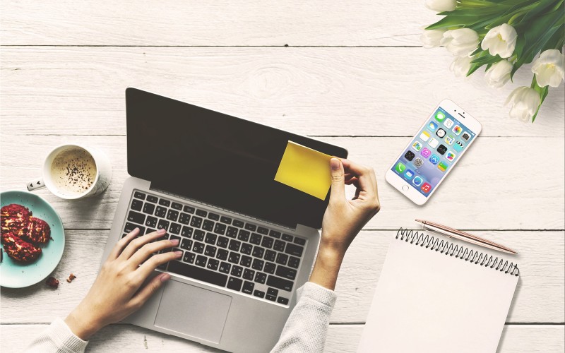 Person mit Notebook und Smartphone