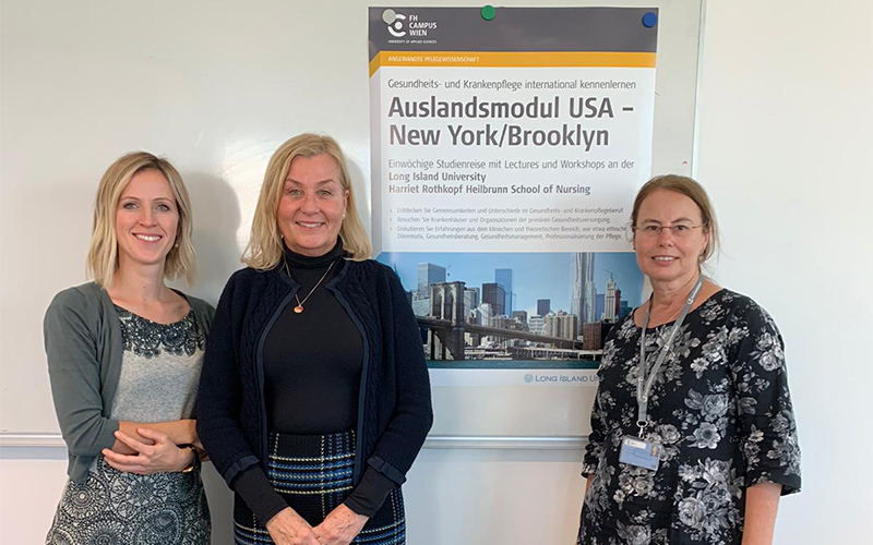 © HCW Anja Patschka, Peggy Tallier, Sabine Schweiger vor dem Plakat, auf dem Information und Brooklyn Bridge zu sehen sind.