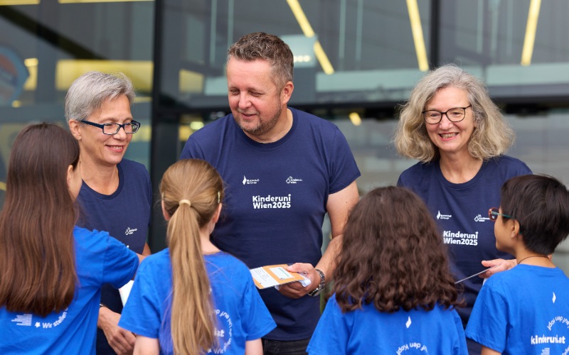Zwei Frauen und ein Mann begrüßen vier Kinder