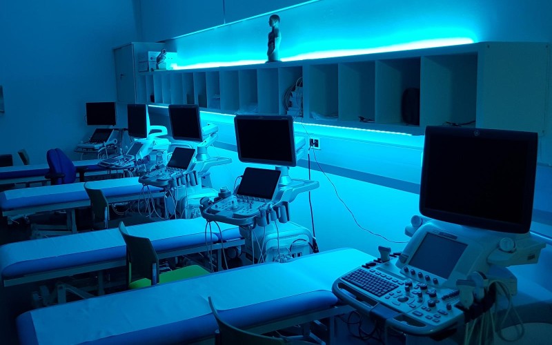 Monitore mit Ultraschallbildern in blau ausgeleuchtetem Raum