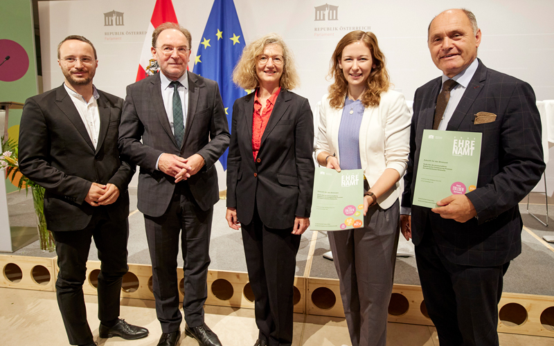 Gruppenbild mit fünf Personen, zwei halten die Studie zum Ehrenamt in die Kamera