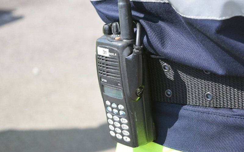 Ausschnitt einer Person in Uniform mit Funkgerät