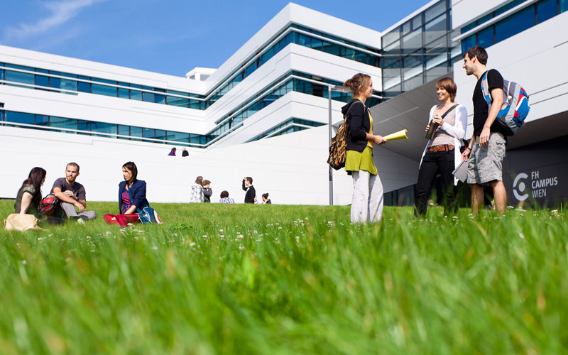 Wiese mit Menschen vor der Hochschule Campus Wien 