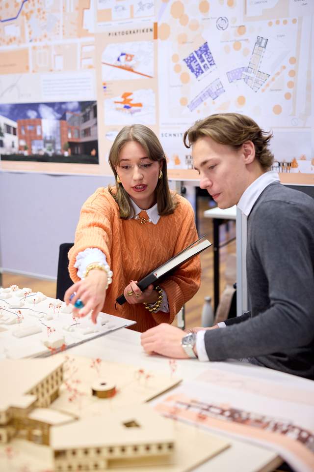 2 Personen sprechen über ein Architekturmodell