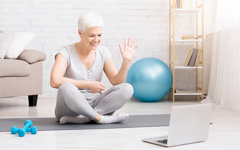 Elderly person with training gear in front of laptop
