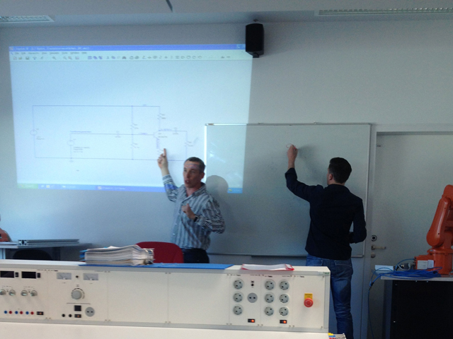 Zwei Lehrpersonen stehen an einer Tafel und unterrichten