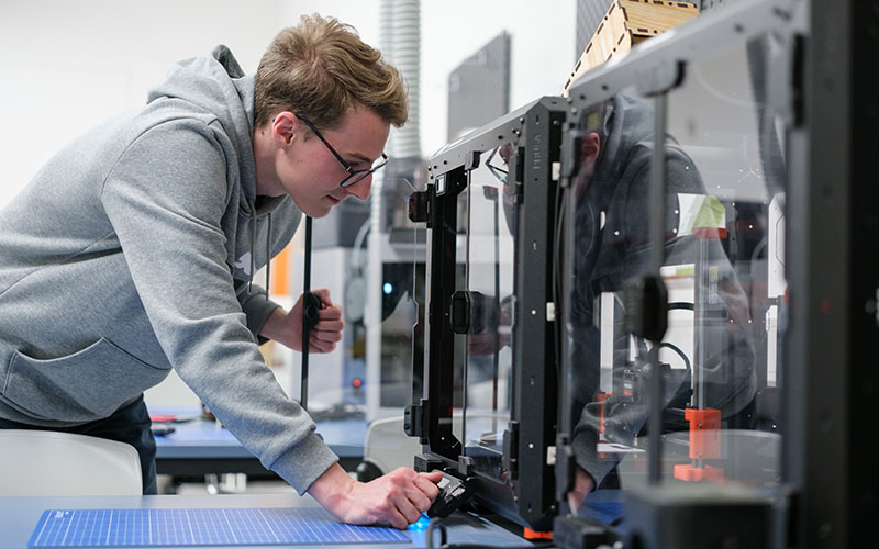 Studierender arbeitet an einem technischen Equipment 