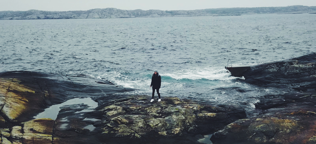 Aufnahme einer Person vor felsiger Küste und Meer