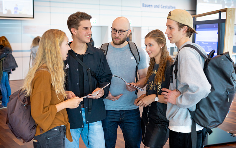 Eine Gruppe Studierende unterhält sich im Foyer der Hochschule