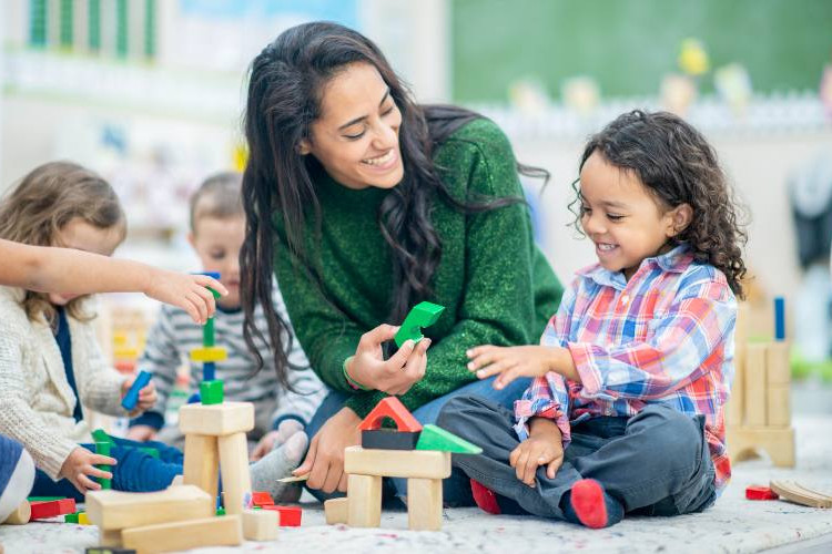 @ FatCamera/istock.com 2 Kinder und erwachsene Person spielen miteinander