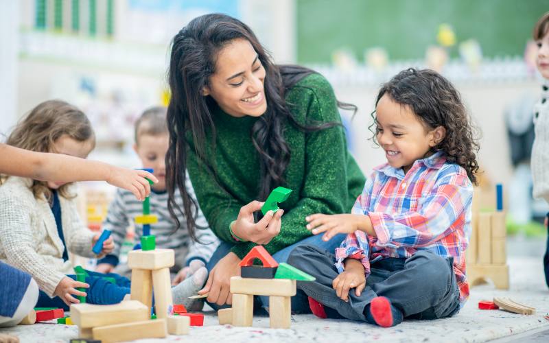 2 Kinder und erwachsene Person spielen miteinander
