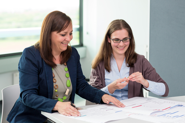 Zwei Damen vor ausgedruckten Tabellen