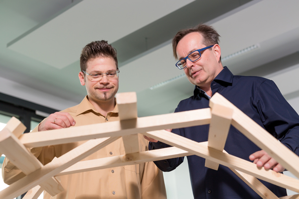 Zwei Herren mit Holzmodell