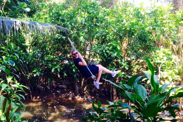 Junge Dame auf Schaukel in vietnamesichen Wald
