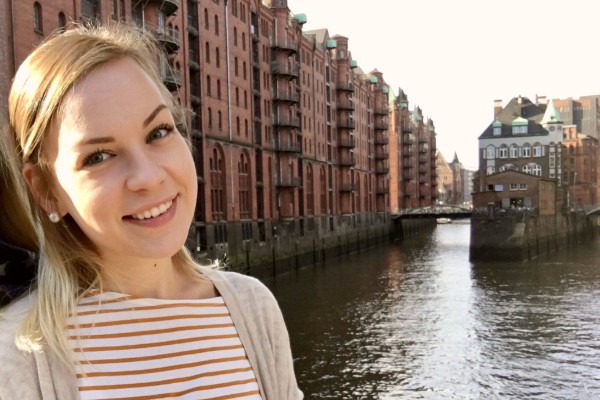 Junge Frau vor Hamburger Kanal mit roten Backsteinhäusern