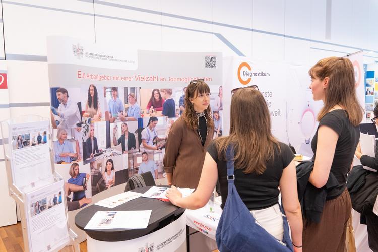 Zwei Studierende am Ausstellerstand am Jobmarket werden beraten