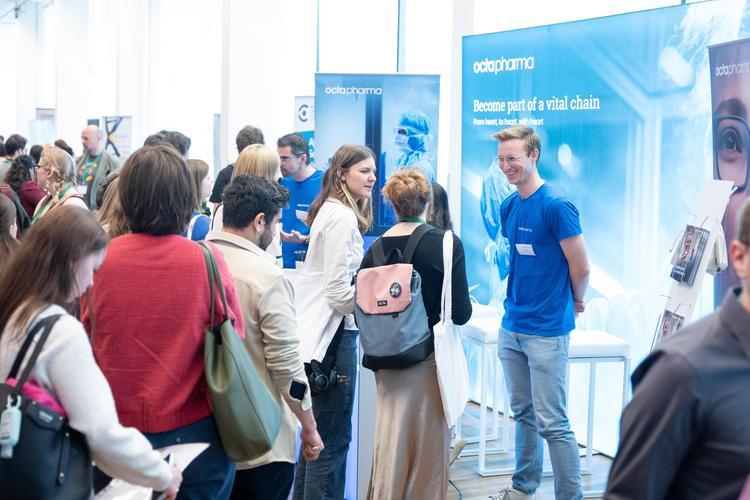 Austellungsstand auf der Life Science Career Fair mit Besucher*innen im Vordergrund